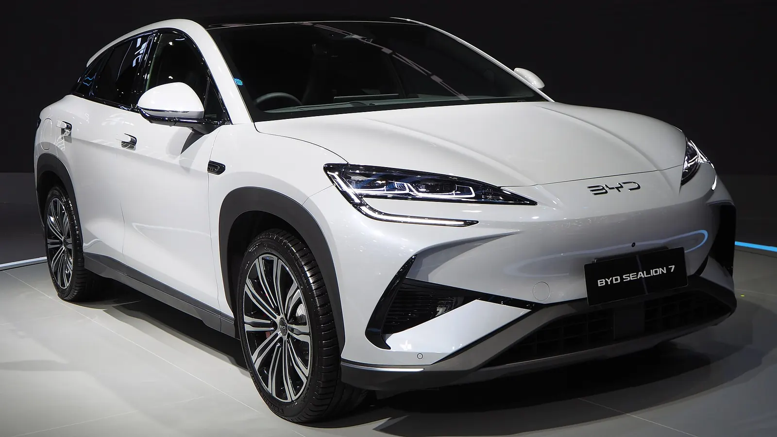 Front three-quarter view of a white BYD Sealion 7 Performance AWD in a studio-style show stand