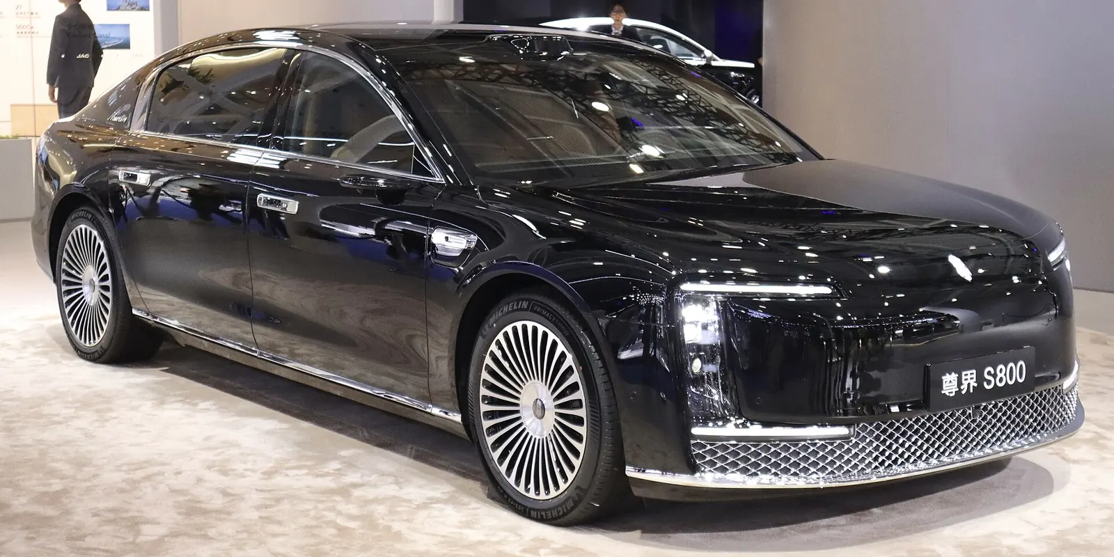 منظر ثلاثي الأرباع من الأمام لسيارة Maextro S800 سوداء على منصة عرض