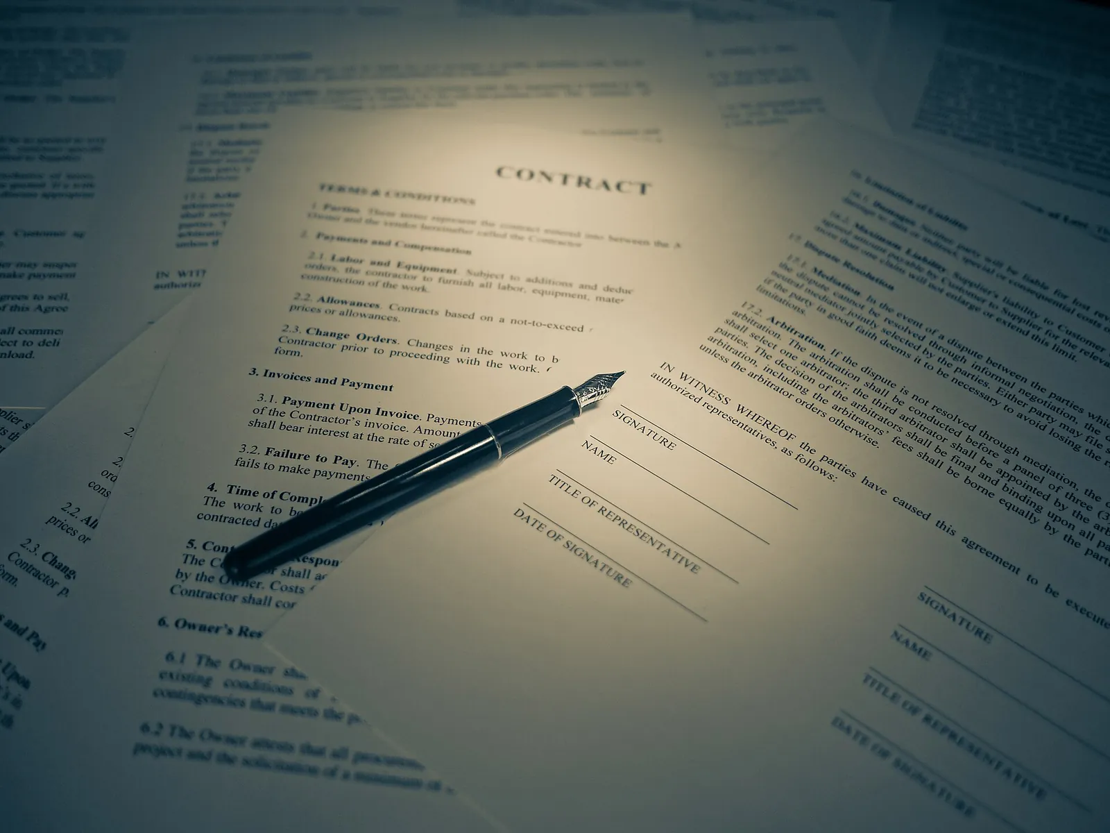 A signed contract and pen on a desk