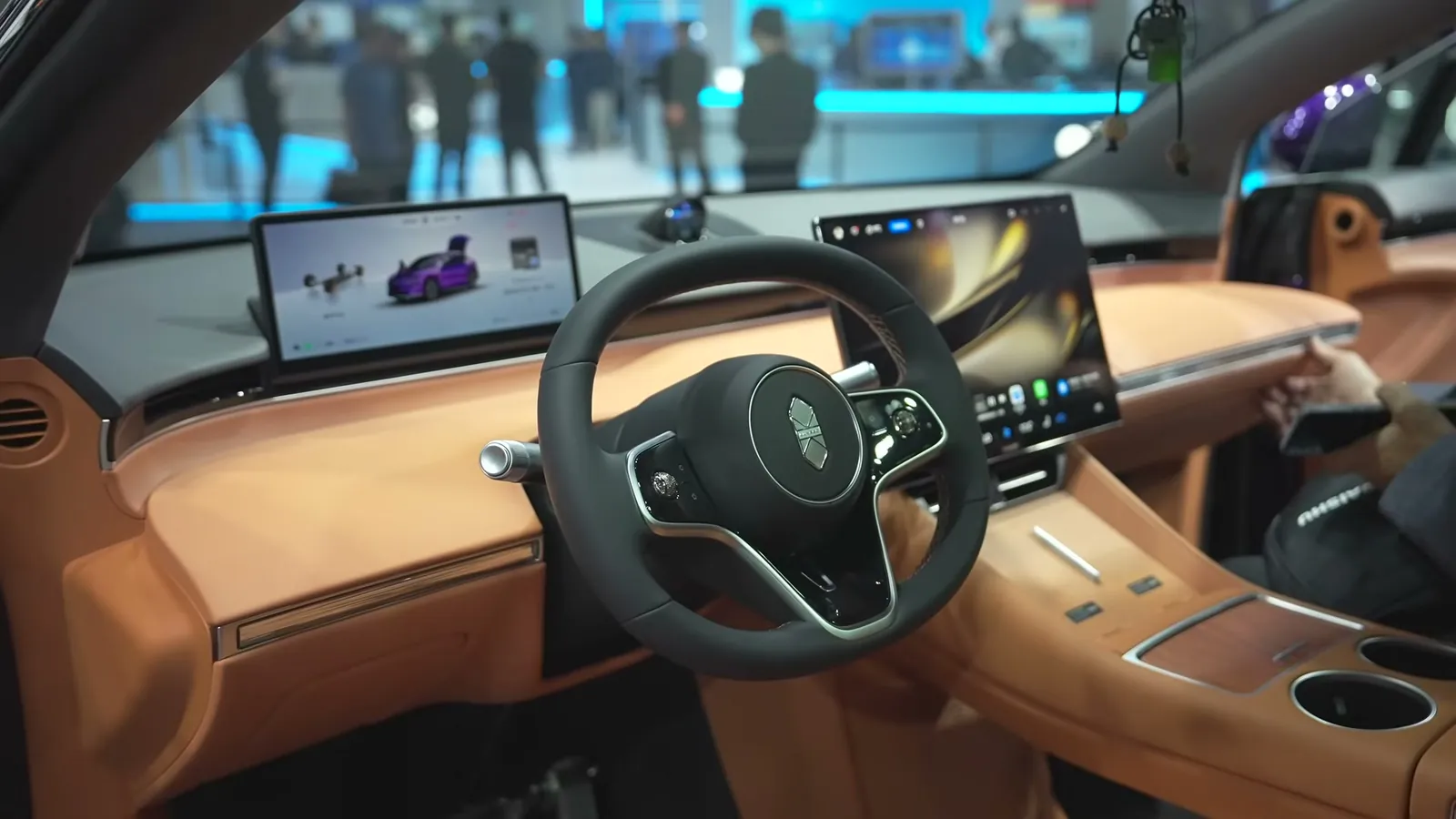 Cockpit of the China-market Luxeed R7 before the 2026 update: steering wheel, small instrument screen, large centre screen and tan leather