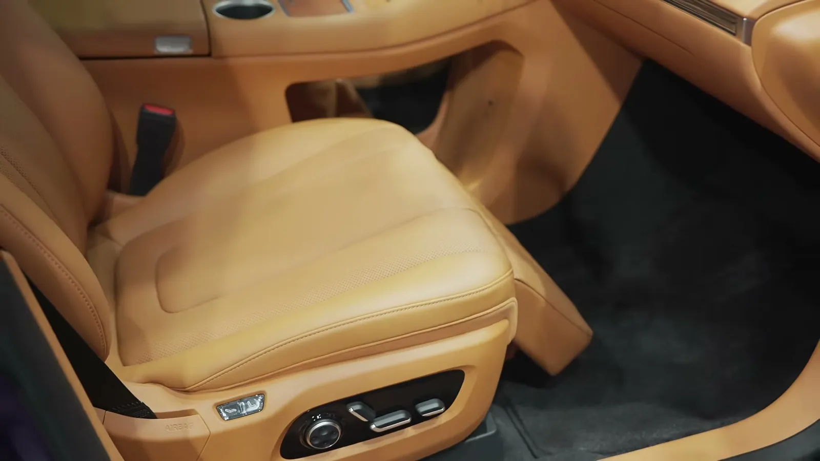 Front passenger seat of the Luxeed R7 with seat controls and tan leather