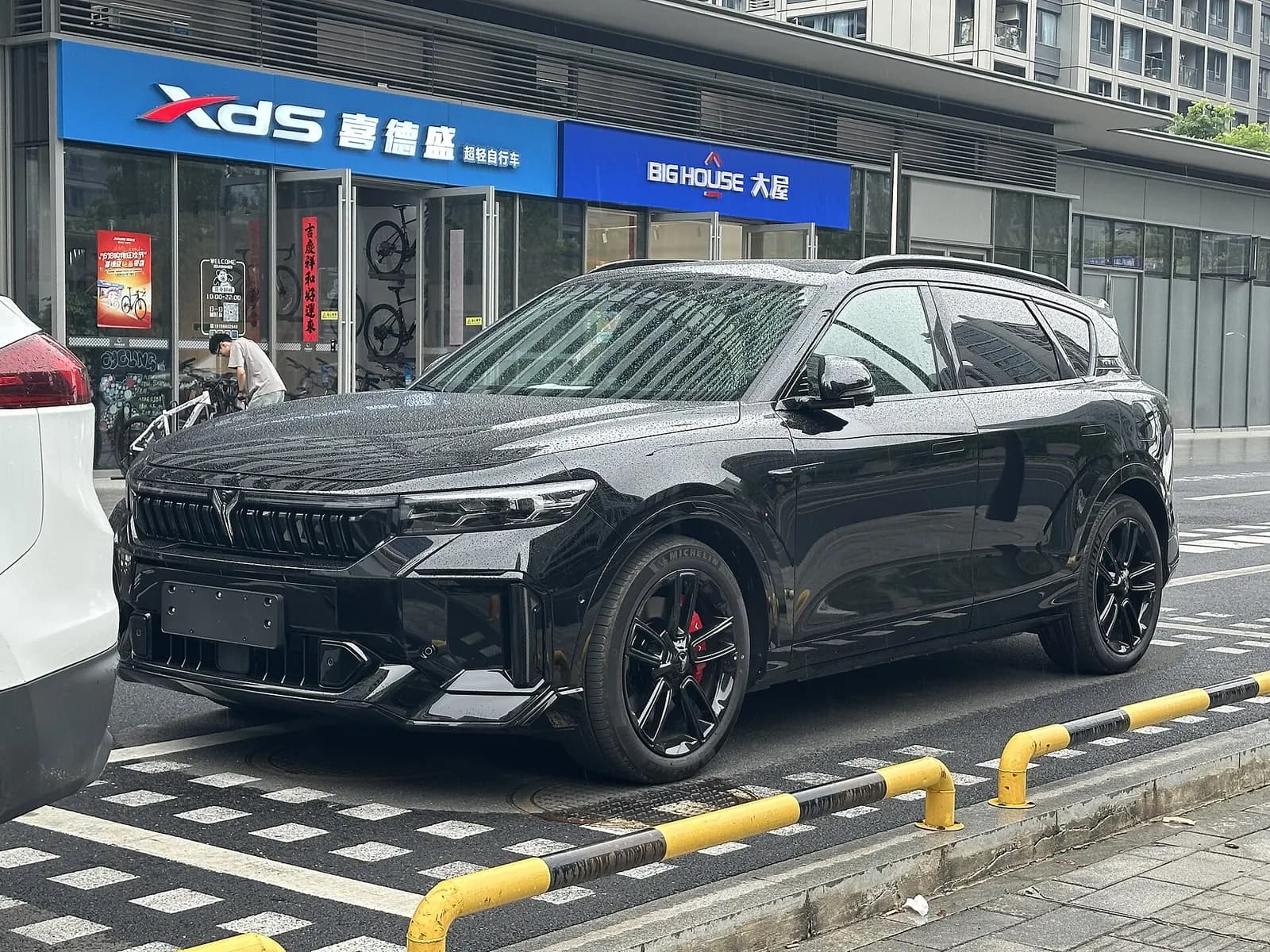 منظر ثلاثي الأرباع من الأمام لسيارة Voyah Free SUV سوداء في شارع بالمدينة